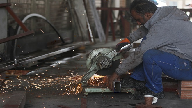 عامل يلحم الحديد في موقع بناء في العاصمة العراقية بغداد